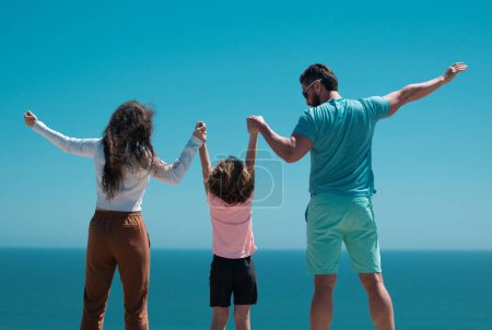 Foto de Feliz familia en la playa. Gente divirtiéndose en vacaciones de verano. Padre, madre e hijo en el mar azul. Concepto familiar despreocupado - Imagen libre de derechos