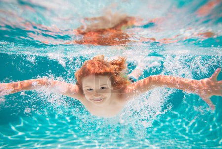 Foto de Chico submarino en la piscina. Niño lindo nadando en la piscina bajo el agua. Niños de verano en el agua en la piscina bajo el agua - Imagen libre de derechos