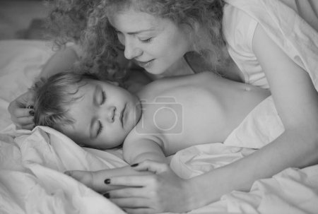 Téléchargez les photos : Mère et bébé dorment dans le lit. Dors tranquillement. Lit, concept d'enfance et de famille, portrait d'intérieur en gros plan - en image libre de droit