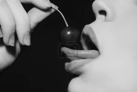 Foto de Cereza en boca de mujer. Frutas sexys de verano. Cerezas en labios de mujer. Lame la lengua cereza, macro, primer plano - Imagen libre de derechos