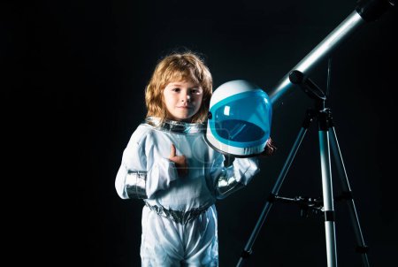 Photo for Child boy with a telescope is dressed in an astronaut costume. Astronomy and astrology concept - Royalty Free Image