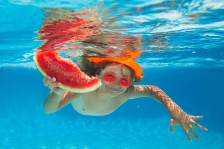 Téléchargez les photos : Enfant nageant dans la piscine sous l'eau. Enfant garçon nager sous l'eau dans la mer. Pastèque d'été - en image libre de droit