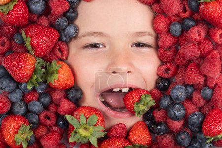 Téléchargez les photos : Vitamines de berrie. Mélange assorti de fraise, myrtille, framboise, fond de mûre. Les baies se rapprochent du visage des enfants. Des baies fraîches, vue de dessus. Mélange de fruits crus de baies fraîches - en image libre de droit
