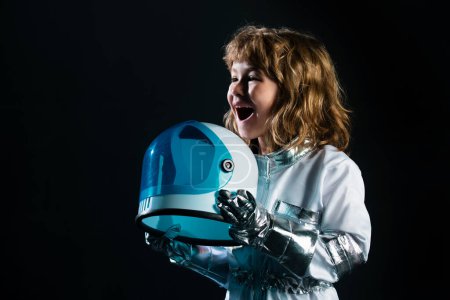 Photo for Little boy wearing an astronaut helmet costume and. Cute kid in astronaut playing and dreaming of becoming a spacemen. Space dream. Dreamy kids face. Daydreamer child portrait close up - Royalty Free Image
