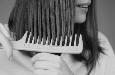 Photo for Close up brushing hair with comb. Combing long hair with hairbrush - Royalty Free Image