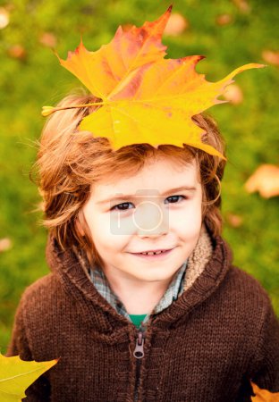 Téléchargez les photos : Joyeux enfant riant et jouant des feuilles en automne à l'extérieur - en image libre de droit