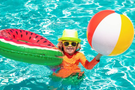 Foto de Niños jugando en la piscina. Actividad de verano. Verano de natación y relax, nadar en el anillo en la piscina, junto a la piscina - Imagen libre de derechos