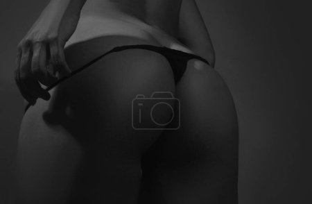 Foto de Sexy butt girl in lingerie. Luxury ass. Huge buttocks. Night sexy background. Beautiful ass of sensual girl with clean skin, nice shapes, fit bottom, intimacy. Sexy girl and underwear concept - Imagen libre de derechos
