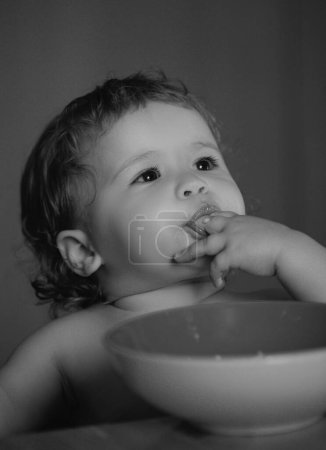 Foto de Niño bebé comer sopa en la cocina con platos y cuchara - Imagen libre de derechos
