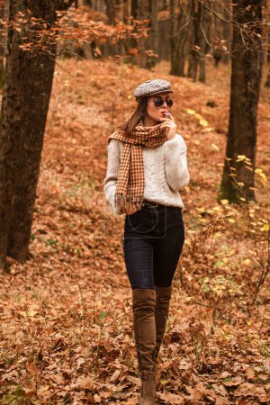Photo for Relaxing smoking. Woman enjoy smoking alone. Lonely smoker. Autumn is here. Pretty woman in hat and sunglasses smoking cigarette forest background. Fall fashion accessory. Enjoy fall season. - Royalty Free Image