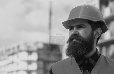Téléchargez les photos : Portrait de constructeur de construction. Homme constructeur travailleur dans casque posant sur le chantier de construction - en image libre de droit