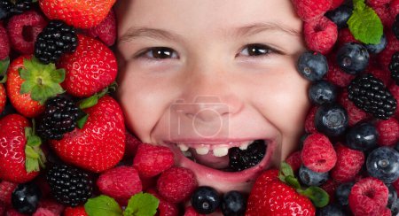Téléchargez les photos : Bannière Berry. Les enfants font face avec des fruits de baies fraîches. Mélange assorti de baies fraise, myrtille, framboise, mûre. Baies nutritionnelles saines pour les enfants. arrière-plan Berry - en image libre de droit