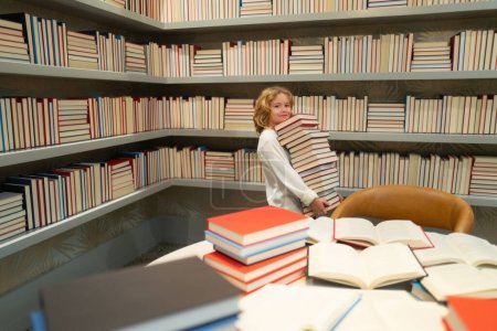 Foto de Niño estudiando en la biblioteca escolar. Libro de lectura infantil en la biblioteca en el fondo de la estantería - Imagen libre de derechos