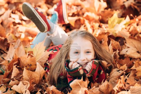 Photo for Happy child girl in autumn leaves outdoors. Playing with leaves. Autumn dream. Kid dreams on autumn nature. Childhood dream concept. Daydreamer child. Dreams and imagination. Dreamy kids face - Royalty Free Image