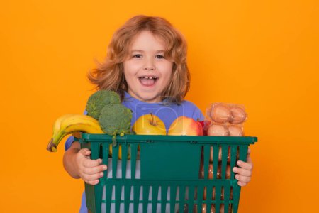 Photo for Sale and discount. Kid at vegetable supermarket. Child with shopping basket. Child choosing food in store or grocery store, isolated background, banner - Royalty Free Image