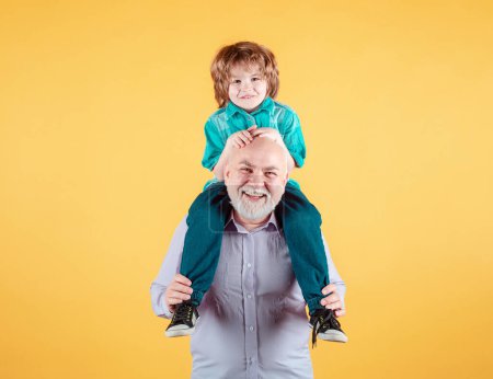 Téléchargez les photos : Grand-père et petit-fils balade à dos de cochon avec drôle de visage isolé. Aîné parent âgé avec enfant - en image libre de droit