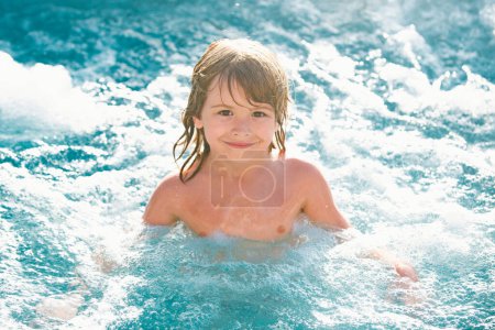 Foto de Lindo chico nadar en la piscina. Activo estilo de vida saludable para niños, actividad deportiva acuática y lecciones para vacaciones familiares de verano con niños. - Imagen libre de derechos