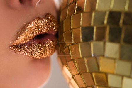Téléchargez les photos : Maquillage des lèvres métaliques dorées. Belle maquillage des lèvres. Sexy brillant à lèvres lumineux - en image libre de droit