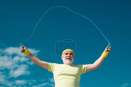 Photo for Portrait of old male senior sportsman skipping rope - Royalty Free Image