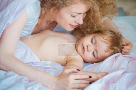 Foto de Madre y bebé durmiendo en la cama. Duerme tranquilo. Hora de acostarse, concepto de infancia y familia, retrato interior de primer plano - Imagen libre de derechos