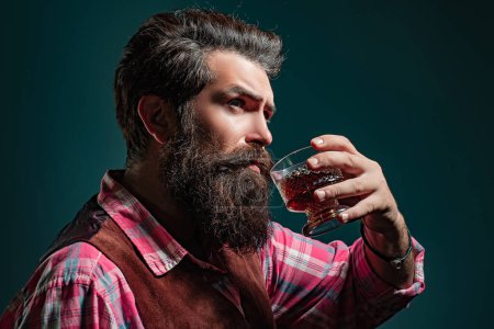 Foto de Hombre camarero con barba sostiene brandy de vidrio. Sommelier sabe bebida alcohólica cara - Imagen libre de derechos