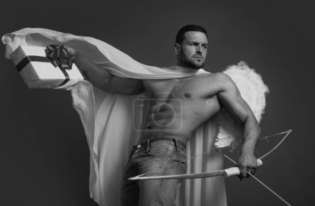 Photo for Sexy man on valentines day. Handsome angel man with angel wings. Great present for girlfriend. Charms of love. Valentine gift. Sexy guy on red background. Cupid shoot with bow and arrows. - Royalty Free Image