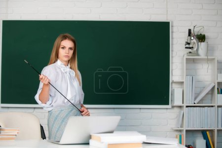 Photo for Young teacher with pointer. Portrait of cute attractive young woman student in university or high school college - Royalty Free Image
