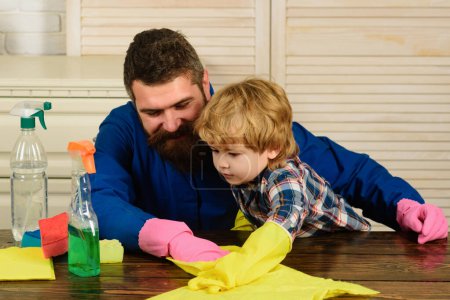 Téléchargez les photos : Nettoyage père et fils. L'homme accoutume le garçon à la propreté - en image libre de droit
