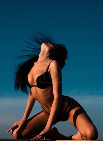 Téléchargez les photos : Art nu, corps parfait en lingerie noire, jeune femme sexy sur fond de ciel - en image libre de droit