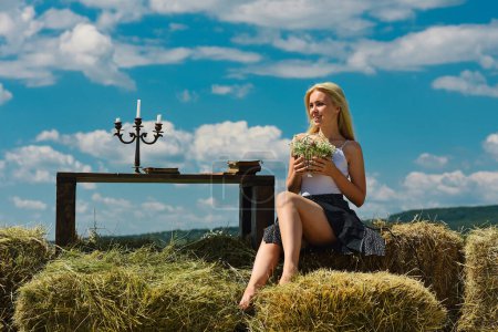 Photo for Countryside woman in boho style with hay stack. Beautiful young woman in fashion dress outdoor. Sexy and sensual female model - Royalty Free Image