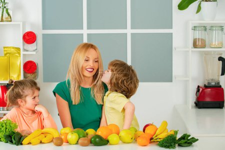 Téléchargez les photos : Maman fille et fils préparent un smoothie dans la cuisine. Amusez-vous et jouez avec les légumes. Alimentation saine et mode de vie pour les enfants. Nutrition végétalienne et mode de vie sain - en image libre de droit