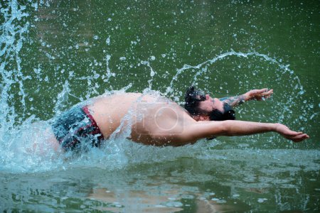 Téléchargez les photos : Homme d'été nageant dans l'eau. Week-end de vacances d'été - en image libre de droit