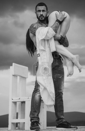 Photo for Latino handsome man and sexy woman. Man is carrying his woman. Love. Couple - Royalty Free Image
