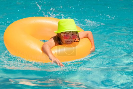 Foto de Salpicaduras de niños y nadar en la piscina. Nadar actividad deportiva acuática en vacaciones de verano con niños. Viajes de verano - Imagen libre de derechos