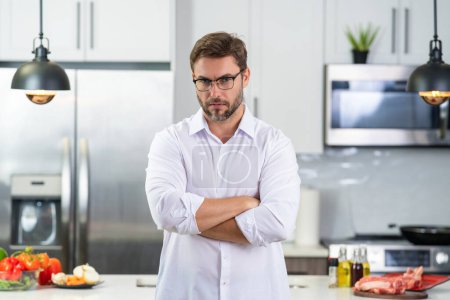 Photo for Chef mature man cooking food in kitchen. Handsome man preparing healthy food in kitchen. Guy cooking a tasty meal. Man on kitchen with meat and vegetables. Portrait of casual guy in kitchen - Royalty Free Image