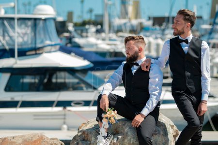 Photo for Portrait of happy gay couple in love on wedding day near yacht boat. Gay marriage. Gay couple wedding. Homosexual couple celebrating wedding, LBGT couple at wedding ceremony, LGBTQ - Royalty Free Image
