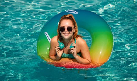 Téléchargez les photos : Vacances d'été. Profitant du bronzage. Femme en maillot de bain sur cercle gonflable dans la piscine - en image libre de droit