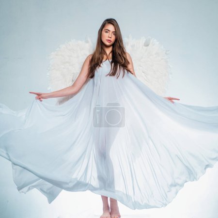 Girl with angel wings and a white dress. Cupid woman