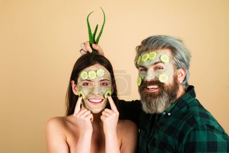 Téléchargez les photos : Couple drôle avec masque de concombres sur le visage. Fille avec soin du visage fraîche peau propre et concept de beauté - en image libre de droit
