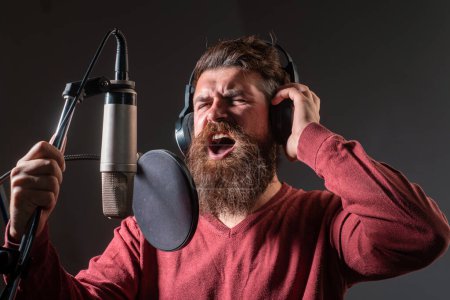 Photo for Sound producer. Handsome man in recording studio. Music performance vocal. Singer singing song with a microphone - Royalty Free Image