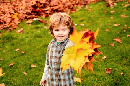 Téléchargez les photos : Portrait extérieur d'automne d'un enfant garçon mignon marchant dans un parc ou une forêt avec une écharpe tricotée chaude - en image libre de droit