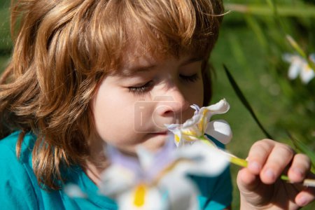 Photo for Happy childhood. Spring kid sniffs flowers. Allergy free concept. Cute child in blossom park - Royalty Free Image