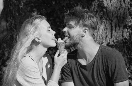 Photo for Cute couple romantic dating and eating ice cream. Young pair sharing icecream. True love. Man with woman in relations - Royalty Free Image