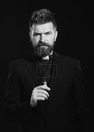 Photo for Religion concept. Handsome hispanic catholic priest man over black isolated background. Pastor or preacher praying, priest portrait of male pastor - Royalty Free Image