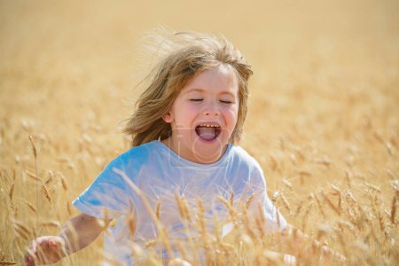 Photo for Happy child on wheat field. Excited boy in the rye fields - Royalty Free Image