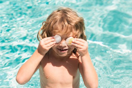 Téléchargez les photos : Joyeux enfant qui s'amuse à la piscine le jour d'été. Enfants jouant dans l'eau de mer bleue. Concept de vacances tropicales d'été. Bonne journée ensoleillée sur la plage de l'île tropicale. Vacances en famille - en image libre de droit