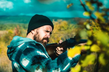 Photo for Man holding shotgun. Hunter with a shotgun in a traditional shooting clothing - Royalty Free Image