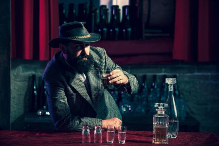 Téléchargez les photos : Homme barbu tenant un verre de whisky - en image libre de droit