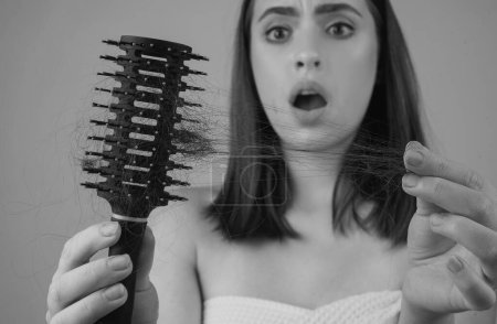 Téléchargez les photos : Triste fille aux cheveux abîmés. Problème de perte de cheveux traitement. Portrait de femme avec un peigne et des cheveux problématiques - en image libre de droit