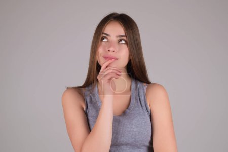 Photo for Thinking concept. Portrait of focused smart and creative woman, holding fingers cheek, with thoughtful expression, thinking. Pensive girl thinking of good deal offer. Portrait of woman thinking - Royalty Free Image